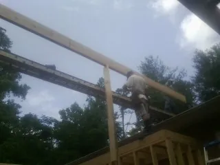 Carpenter setting a ridge beam over a new addition frame — Ice Dam Removal by Roofing Brothers in Horseshoe Bend