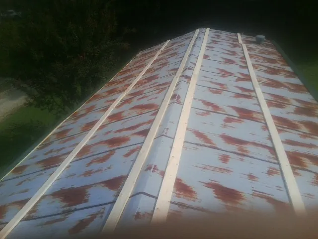 Rusted metal roof panels with new wood purlins before replacement — Storm Damage Roof Repair in Horseshoe Bend by Roofing Brothers