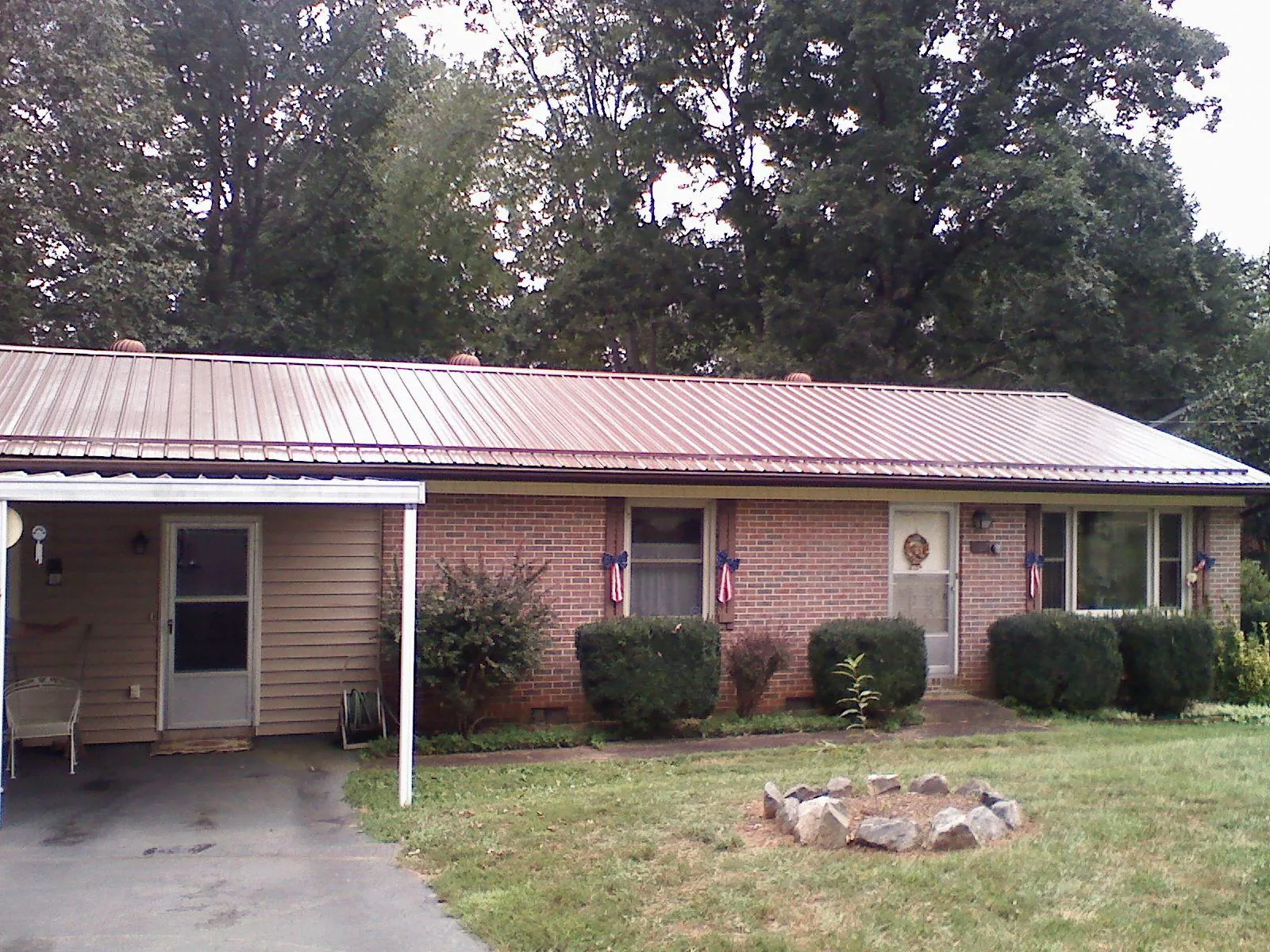 Bronze metal roof and carport on a brick ranch home — Roof Repair work by our crew in Horseshoe Bend